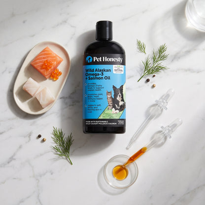 Wild Alaskan Omega-3 Salmon Oil on marble with fresh salmon, dill and a dropper of oil