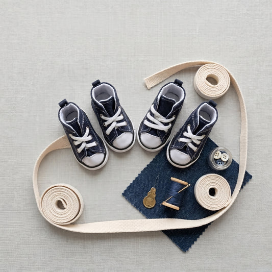 Waterproof Denim Pet Sneakers in navy, flat lay with cotton webbing, denim swatch, buttons, thread and needle
